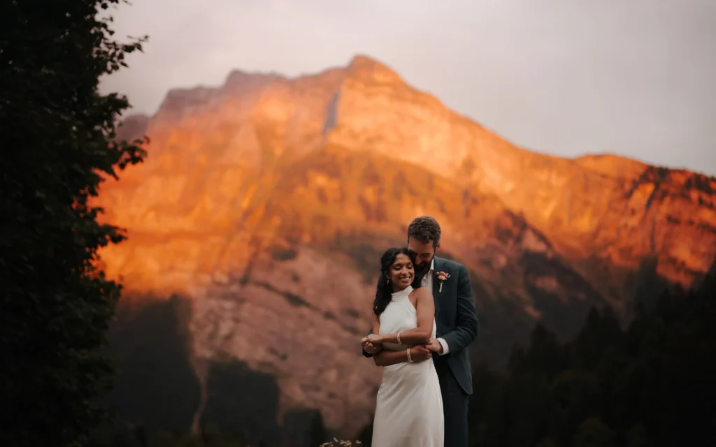 a just married couple dancing in front of a mountain